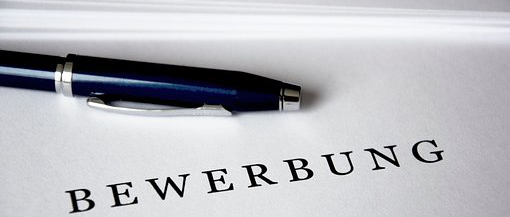 Stift auf Papier, auf dem 'Bewerbung' steht
